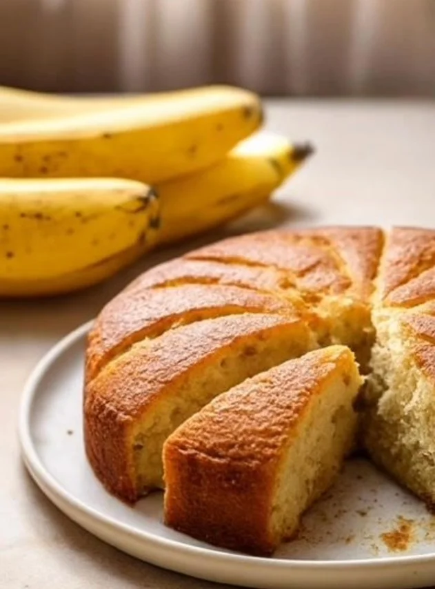 Banana Cake Delicious homemade banana cake with frosting and banana slices on top.